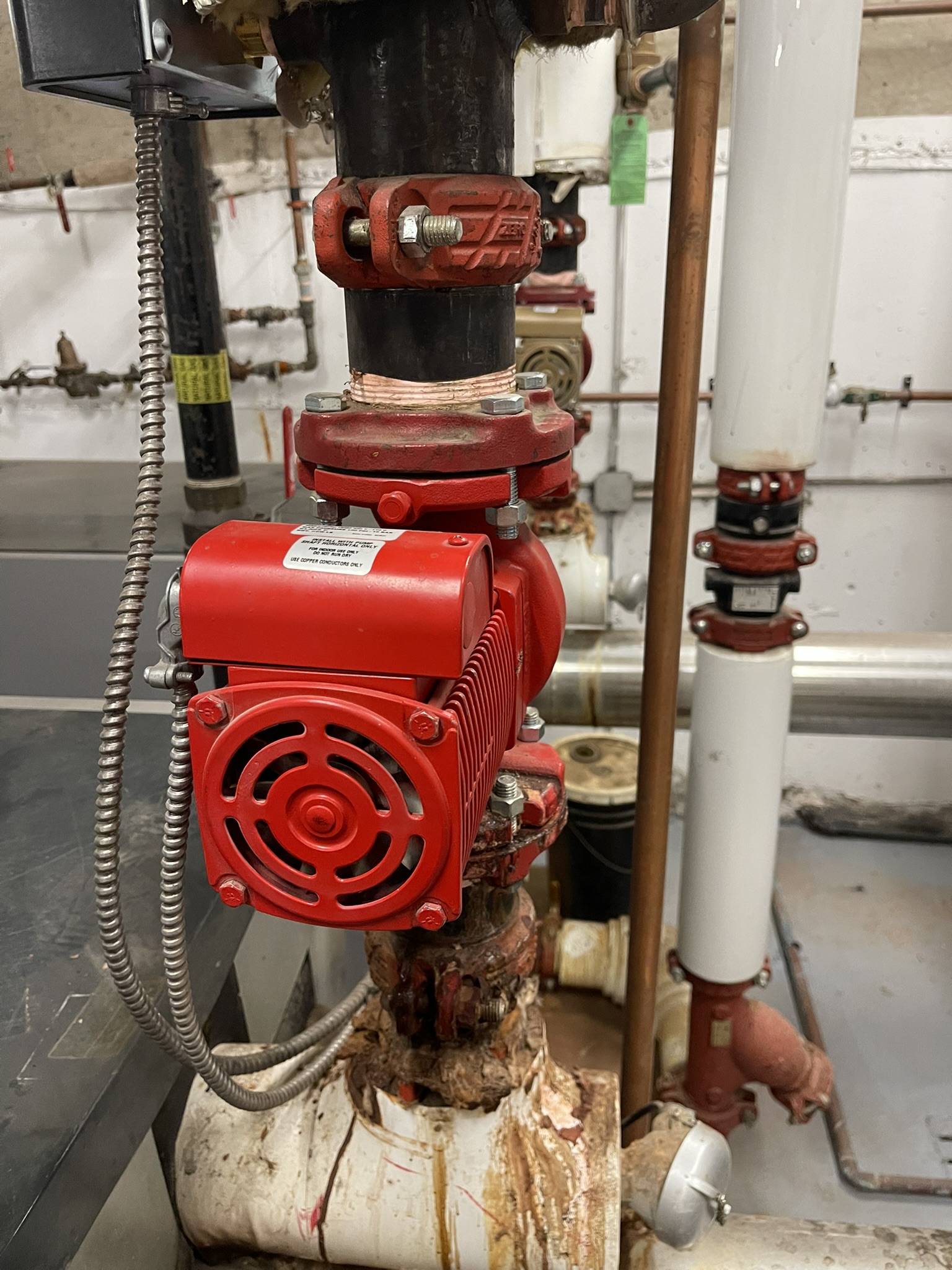 Red circulator pump with copper piping and grooved couplings